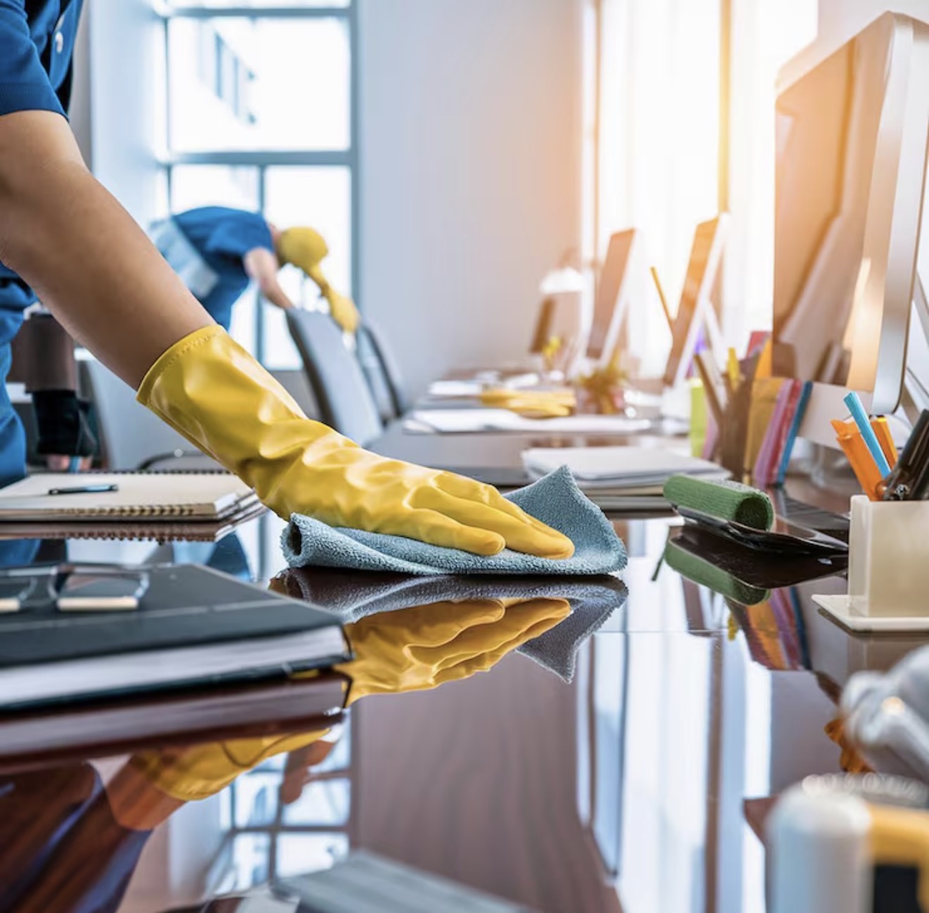 Cleaner polishing an executive desk to a mirror shine